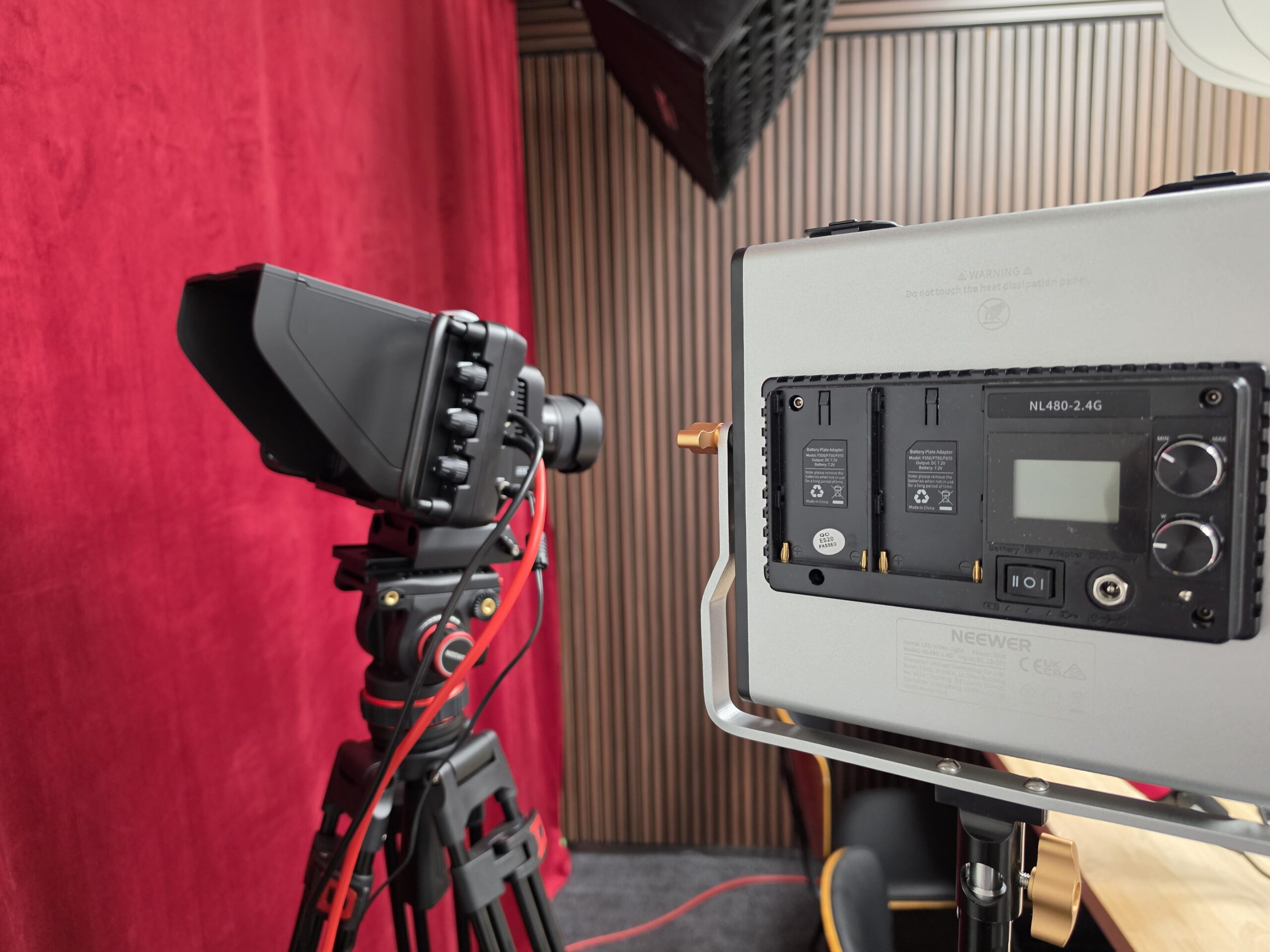 Camera and studio light set up in front of the red curtain backdrop
